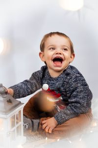 &quot;Ein strahlender 1-j&auml;hriger Junge vor einem Hintergrund aus Sternen. Weihnachtliches Fotoshooting mit mobilem Fotostudio in Kaufbeuren.&quot;