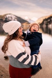 &quot;Eine Mutter k&uuml;sst liebevoll ihr Kind, das das Down-Syndrom hat, am Alpsee in F&uuml;ssen. Im Hintergrund sind die Berge und die Naturvielfalt vom Allg&auml;u zu sehen. Das Foto wurde von Pongratz Photography aufgenommen.&quot;