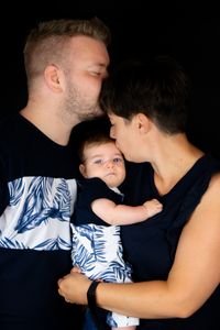 Eine gl&uuml;ckliche Familie, bestehend aus Mutter, Vater und Kind, lacht fr&ouml;hlich vor einer schwarzen Leinwand, die von einem mobilen Fotostudio in Kaufbeuren aufgebaut ist. Das Foto wurde von Pongratz Photography gemacht.&quot;