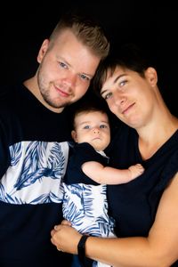 Eine gl&uuml;ckliche Familie, bestehend aus Mutter, Vater und Kind, lacht fr&ouml;hlich vor einer schwarzen Leinwand, die von einem mobilen Fotostudio in Kaufbeuren aufgebaut ist. Das Foto wurde von Pongratz Photography gemacht.&quot;